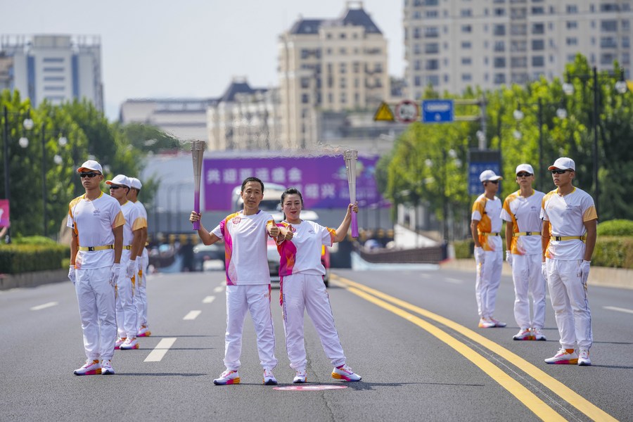 Torch bearers Shan Jie (L) and Zhang Di pose during the torch relay of the 19th Asian Games in Shaoxing, China's Zhejiang Province, September 11, 2023. /CFP