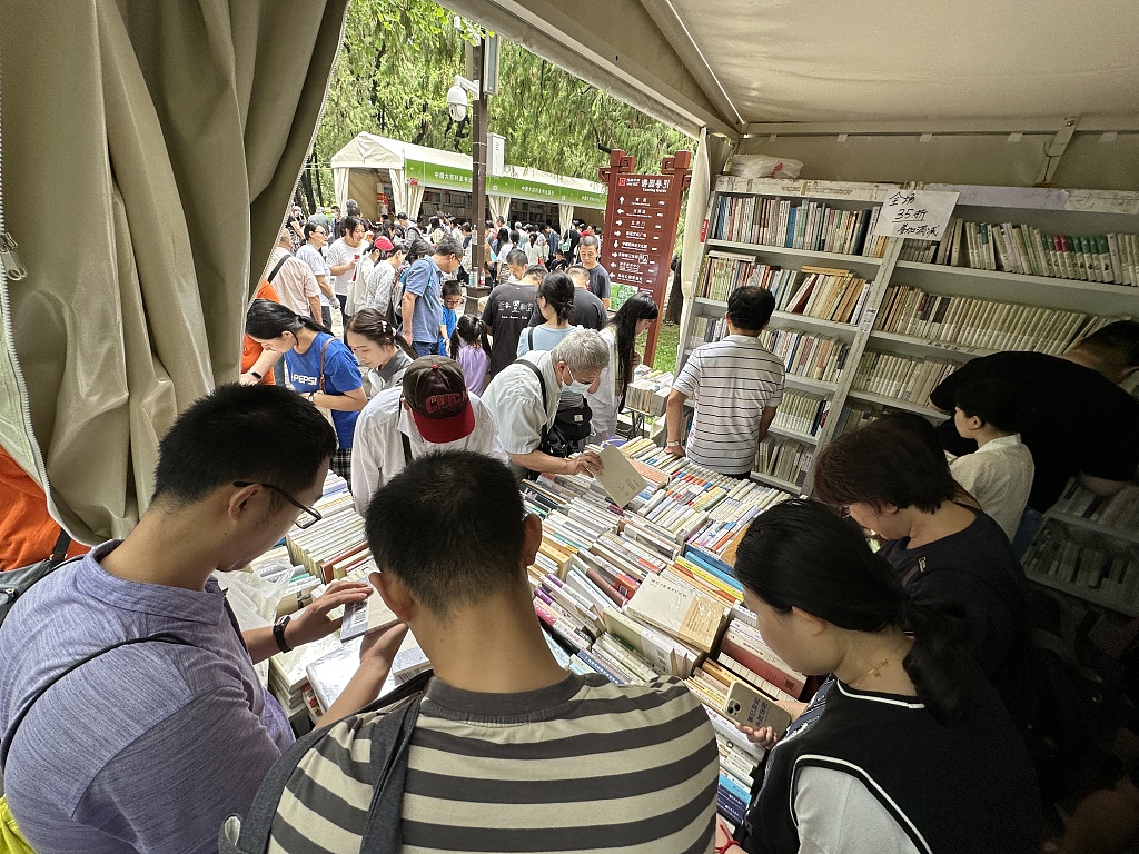 Visitors select titles at the book fair in Ditan Park, Beijing, September 10, 2023. /CFP