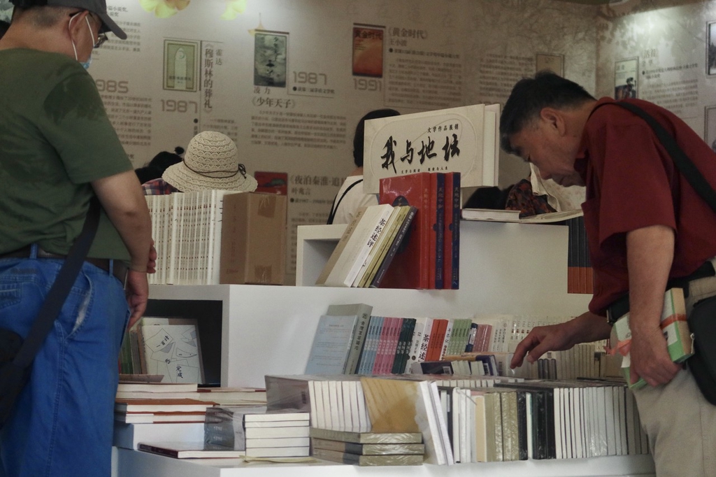 Visitors select titles at the book fair in Ditan Park, Beijing, September 10, 2023. /IC