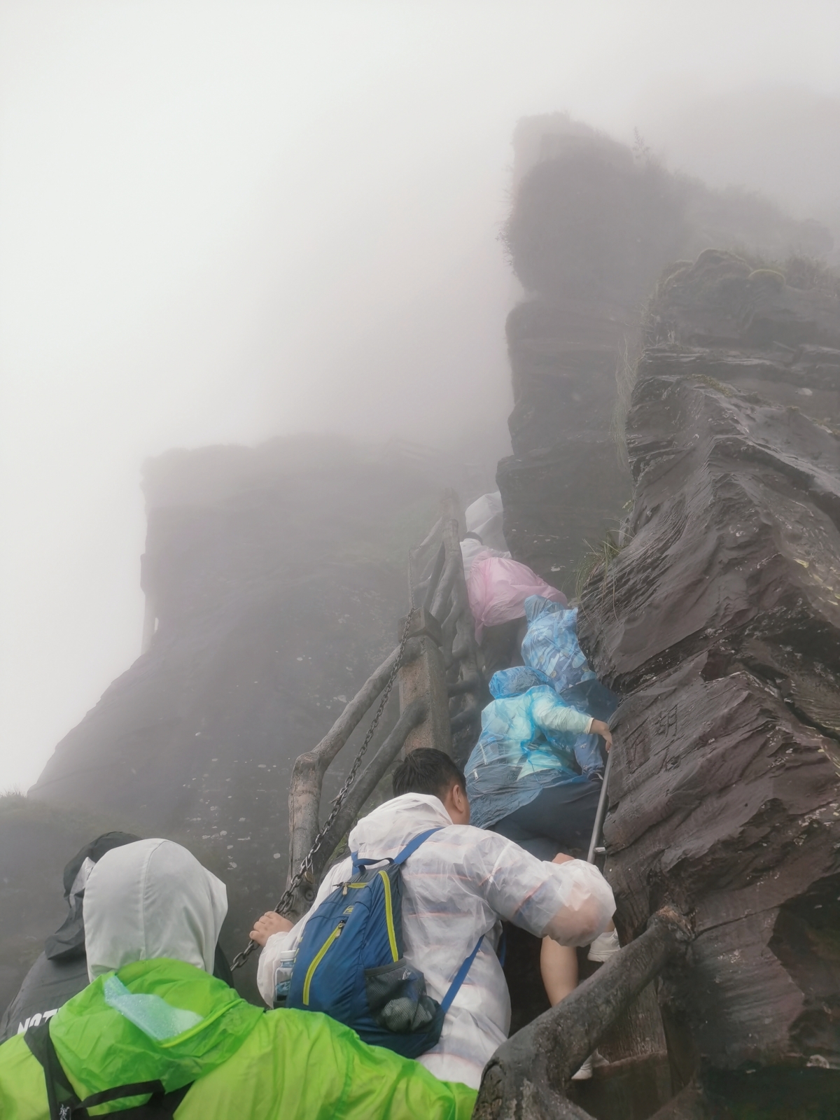 Tourists climb in the rain up to Red Cloud Golden Peak (New Golden Peak) on Mount Fanjing, in Tongren, southwest China's Guizhou Province, on August 25, 2023. /CGTN