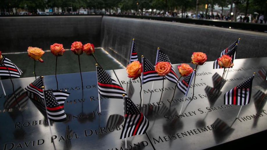 Flowers and flags are seen placed on plates inscribed with names of 9/11 victims at the National September 11 Memorial and Museum in New York, the United States, September 11, 2023. /Xinhua