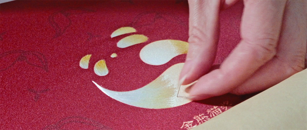 An artisan embroiders the logo for the Golden Panda Awards onto a piece of red silk to make the certificates for the awards. /Photo provided to CGTN