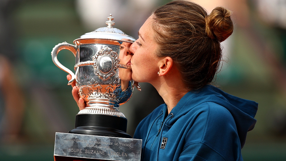 Simona Halep kisses the trophy as she celebrates victory following the women's singles final of the French Open at Roland Garros in Paris, France, June 9, 2018. /CFP