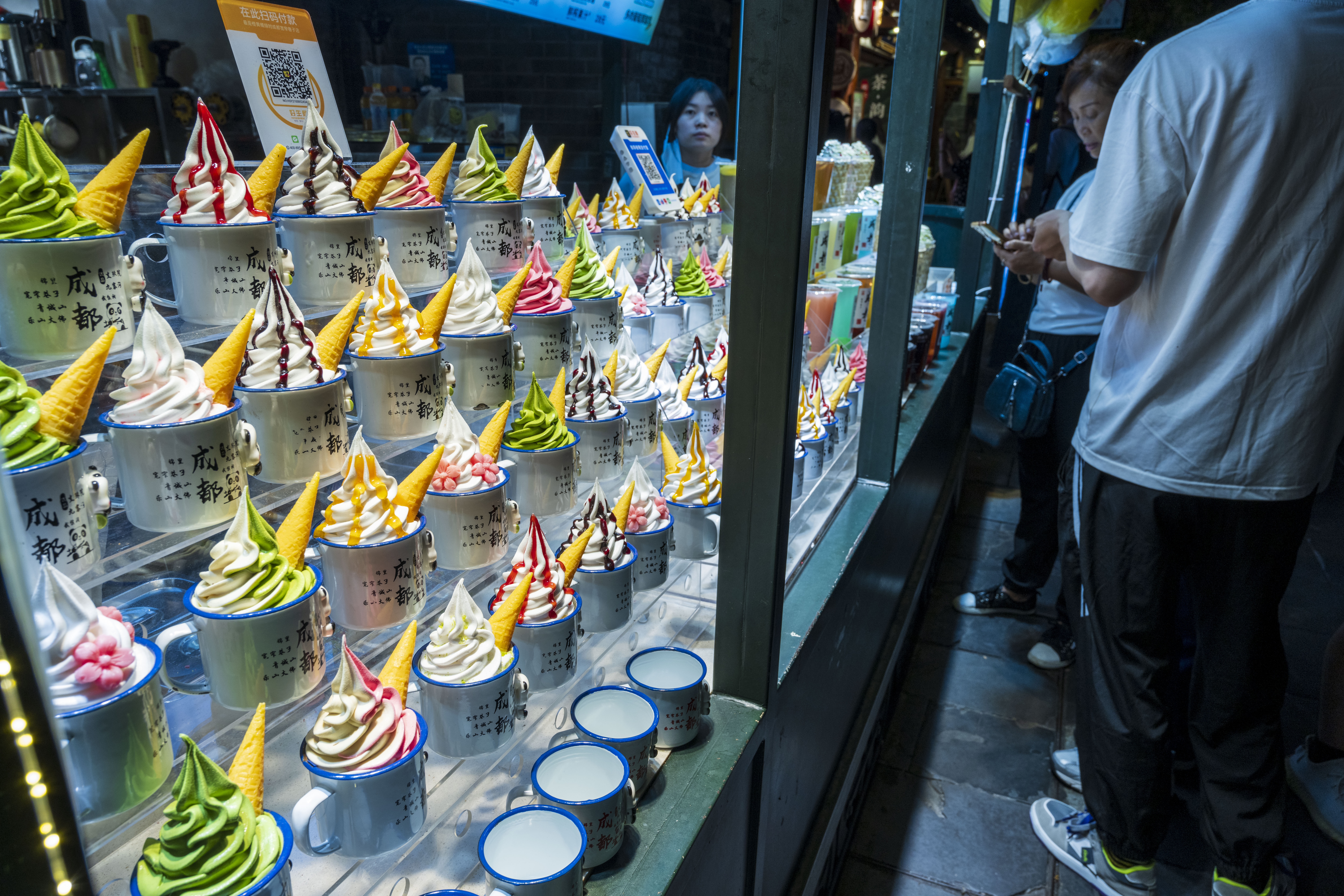 A photo shows pedestrians stopping to browse a range of new ice creams displayed in a shop window in Chengdu, Sichuan on September 9, 2023. /IC