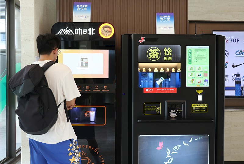 A visitor uses a smart coffee vending machine at the Asian Games Village in Hangzhou, Zhejiang Province, September 12, 2023. /CFP