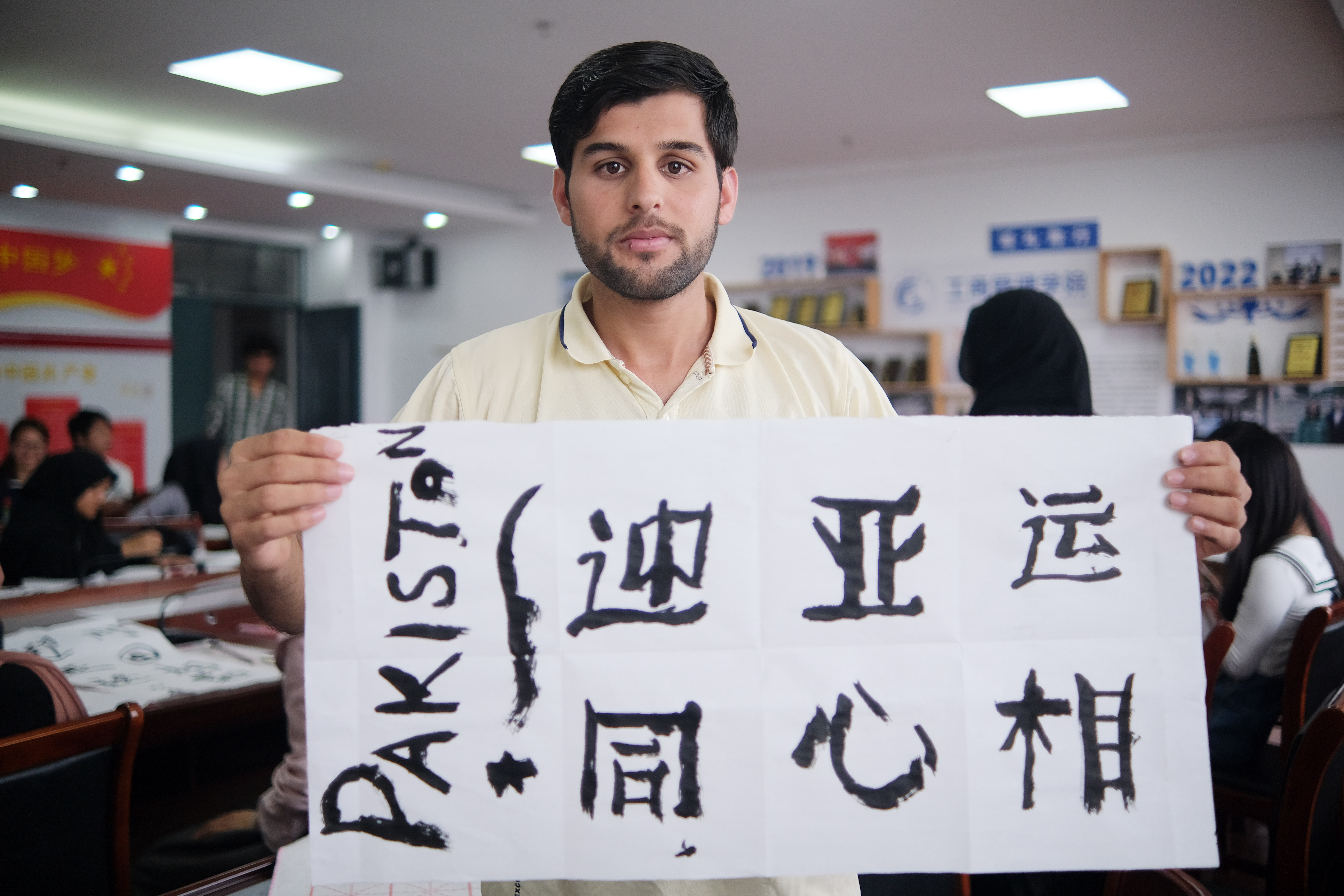 A photo taken on September 13, 2023 shows an international student displaying his calligraphy work as part of an Asian Games well-wishing activity held in Nantong, Jiangsu. /IC