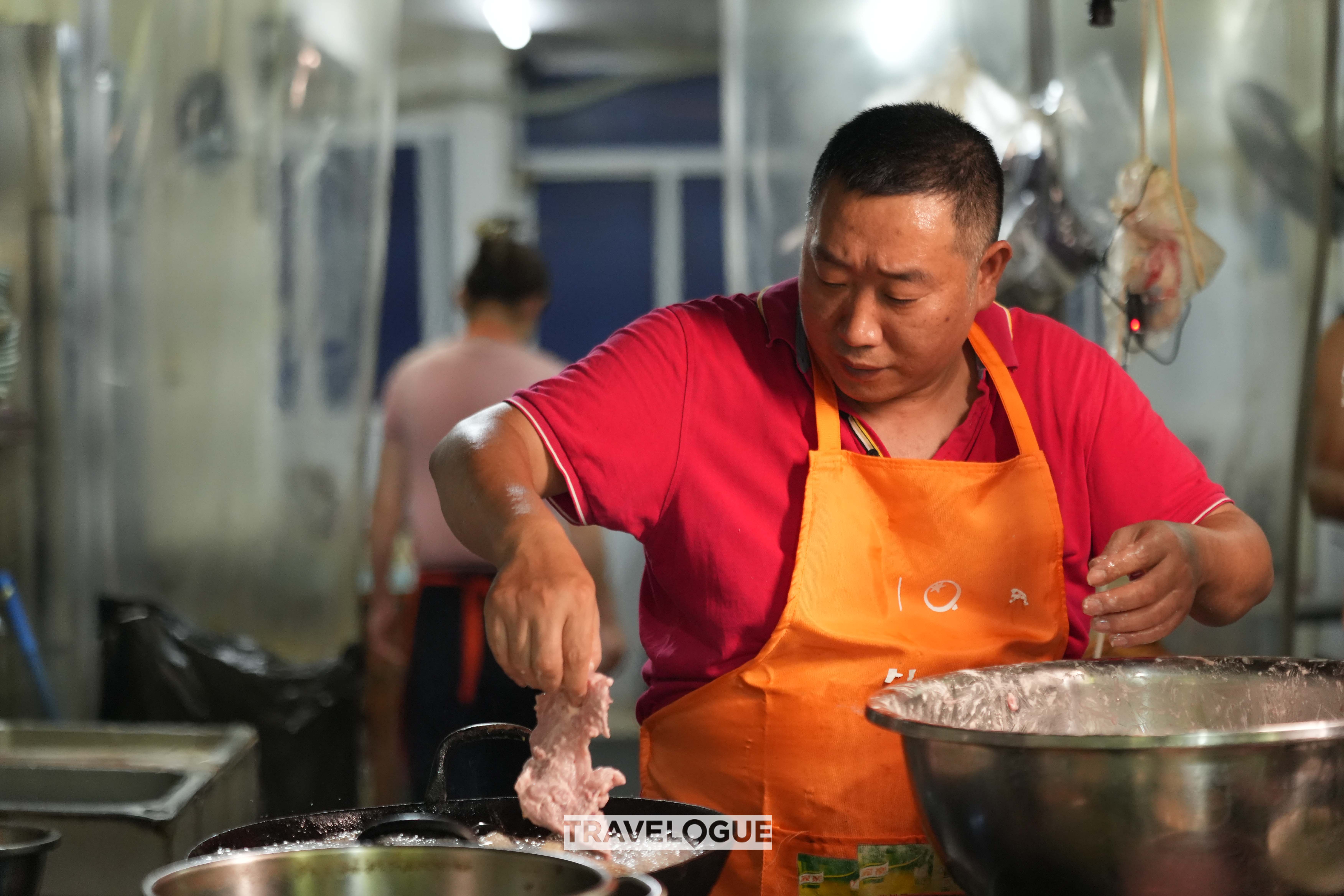 A chef cooks the dish's toppings in Hangzhou, Zhejiang Province. /CGTN