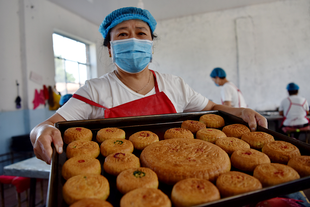 A worker shows traditional mooncakes made with flax oil at a food factory in Pangjiabao Town of Zhangjiakou, north China's Hebei Province on September 14, 2023. /CGTN