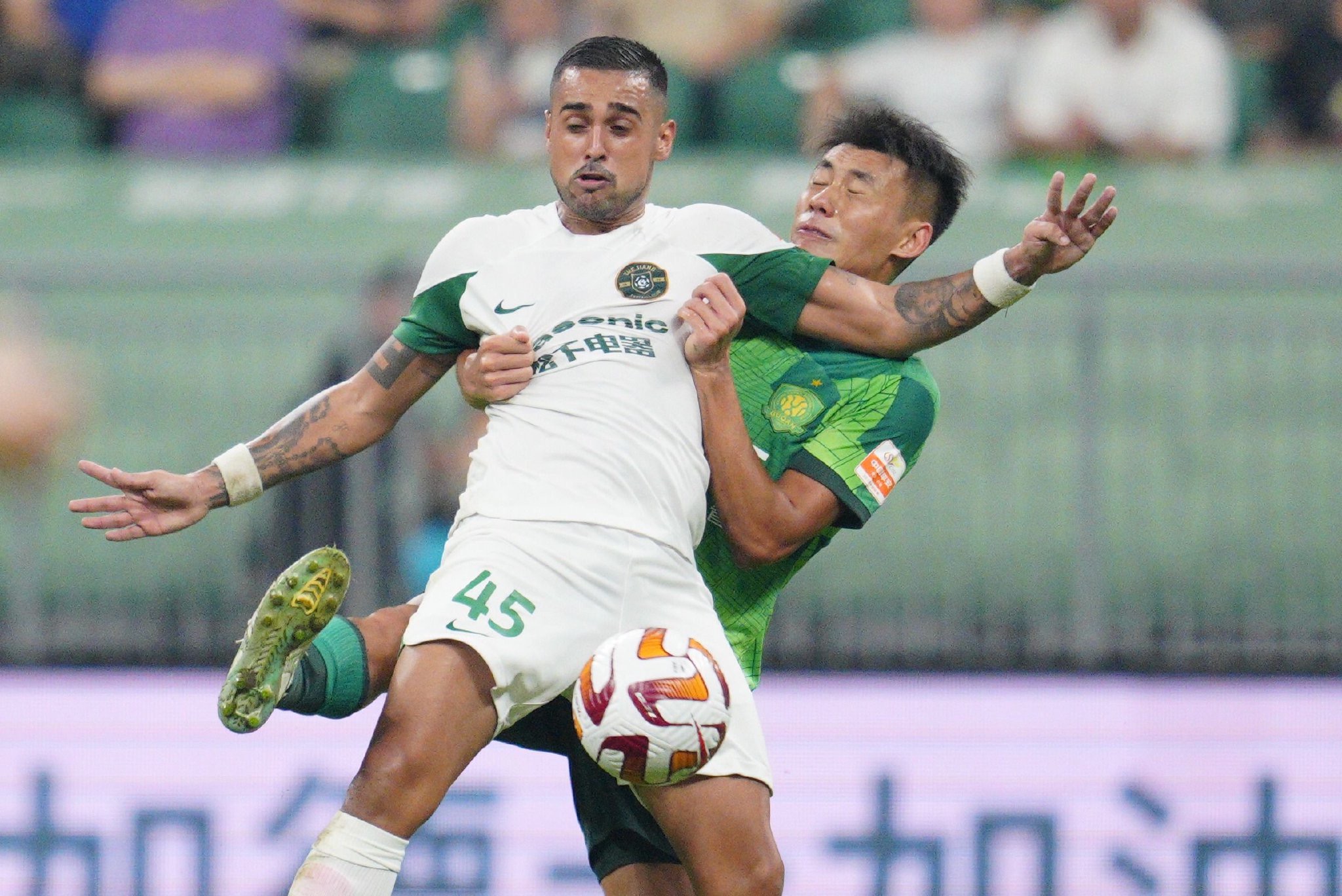 Zhejiang FC's Leonardo is tackled from behind by Beijing Guoan's Zhang Chengdong during their Chinese Super League clash at the new Workers' Stadium in Beijing, China, September 15, 2023. /Beijing Guoan