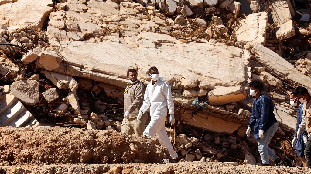 Rescuers walk in front of buildings that collapsed during floods after the Mediterranean storm 