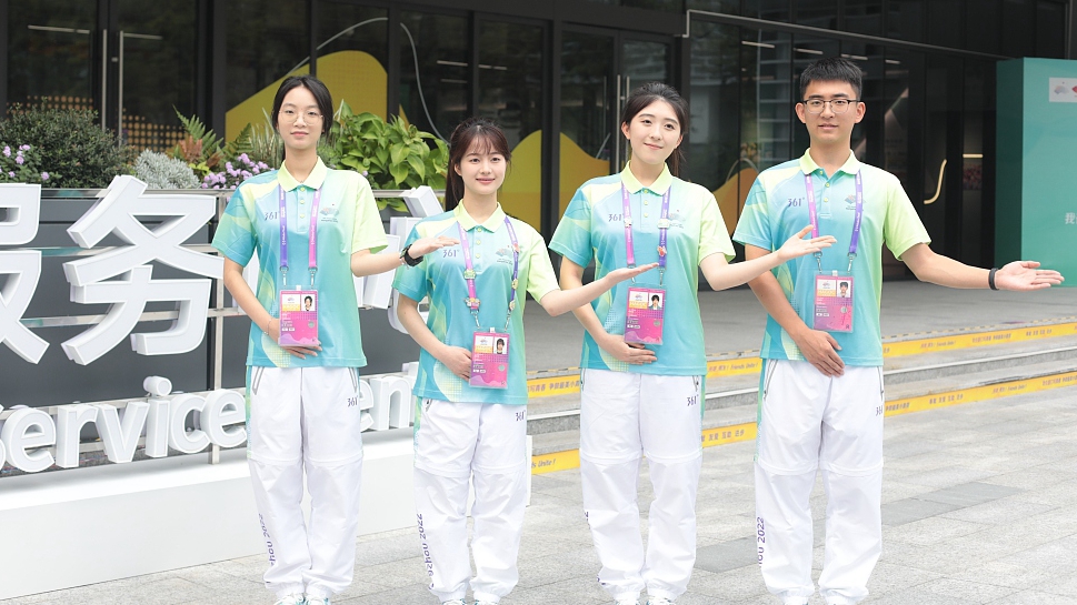 Volunteers stand in front of the services center of the Hangzhou Asian Games Village in Zhejiang Province, China, September 17, 2023. /CFP