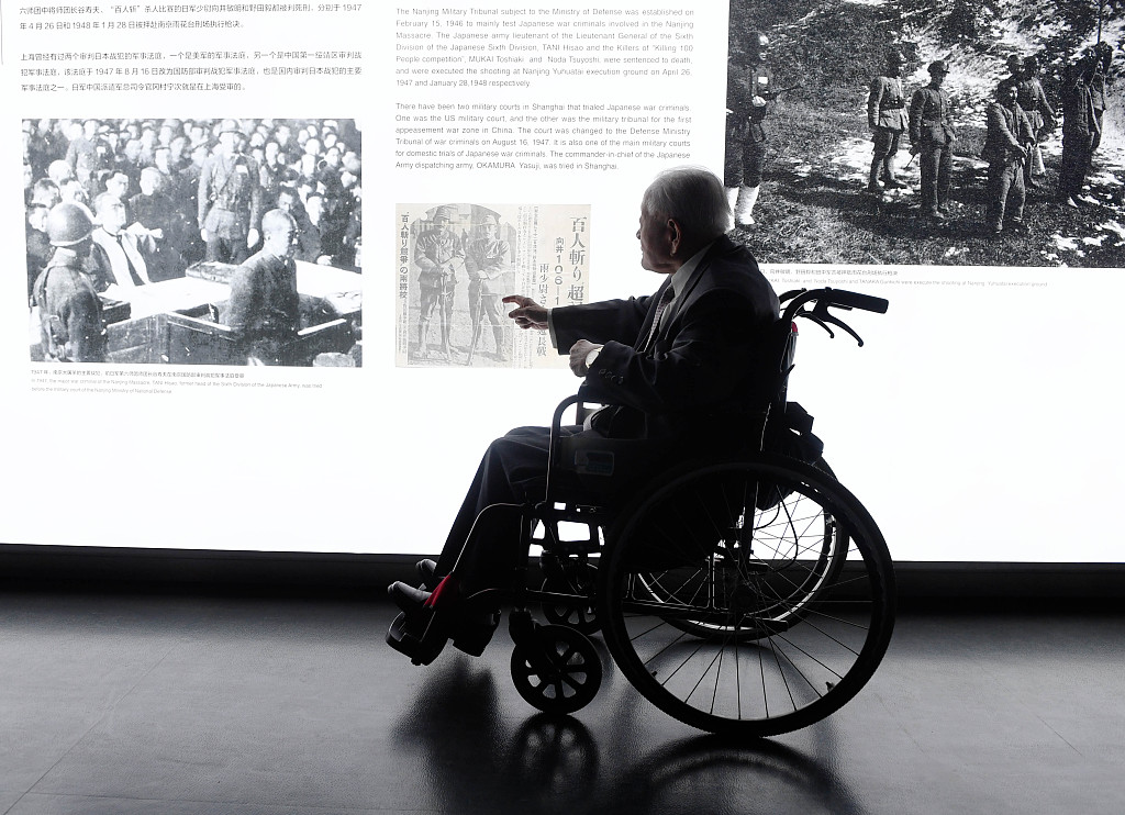 An elderly man in a wheelchair looks over the historical information on the Nanjing Massacre by Japanese invaders, at the Memorial Hall of the Victims in the Nanjing Massacre in Nanjing, east China's Jiangsu Province, September 18, 2019. /CFP