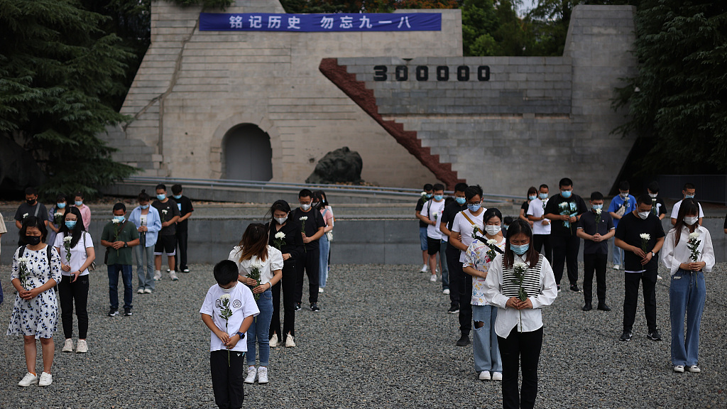 People hold flowers and observe a moment of silence to commemorate the September 18 Incident and remember the victims of the Chinese People's War of Resistance Against Japanese Aggression, in Nanjing, east China's Jiangsu Province, September 18, 2022. /CFP