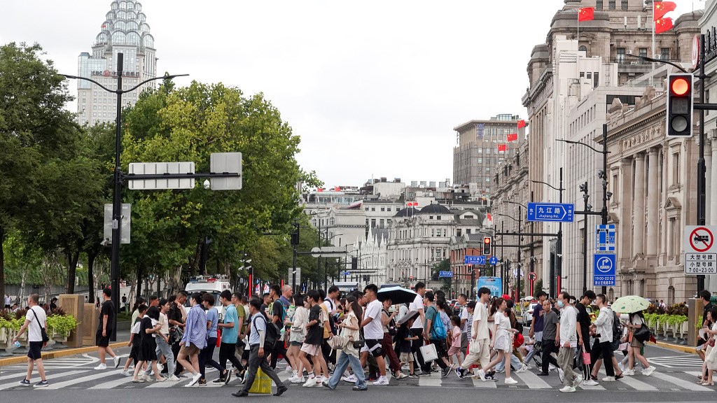 Pedestrians crossing a road near the Bund in Shanghai, July 26, 2023. /CFP