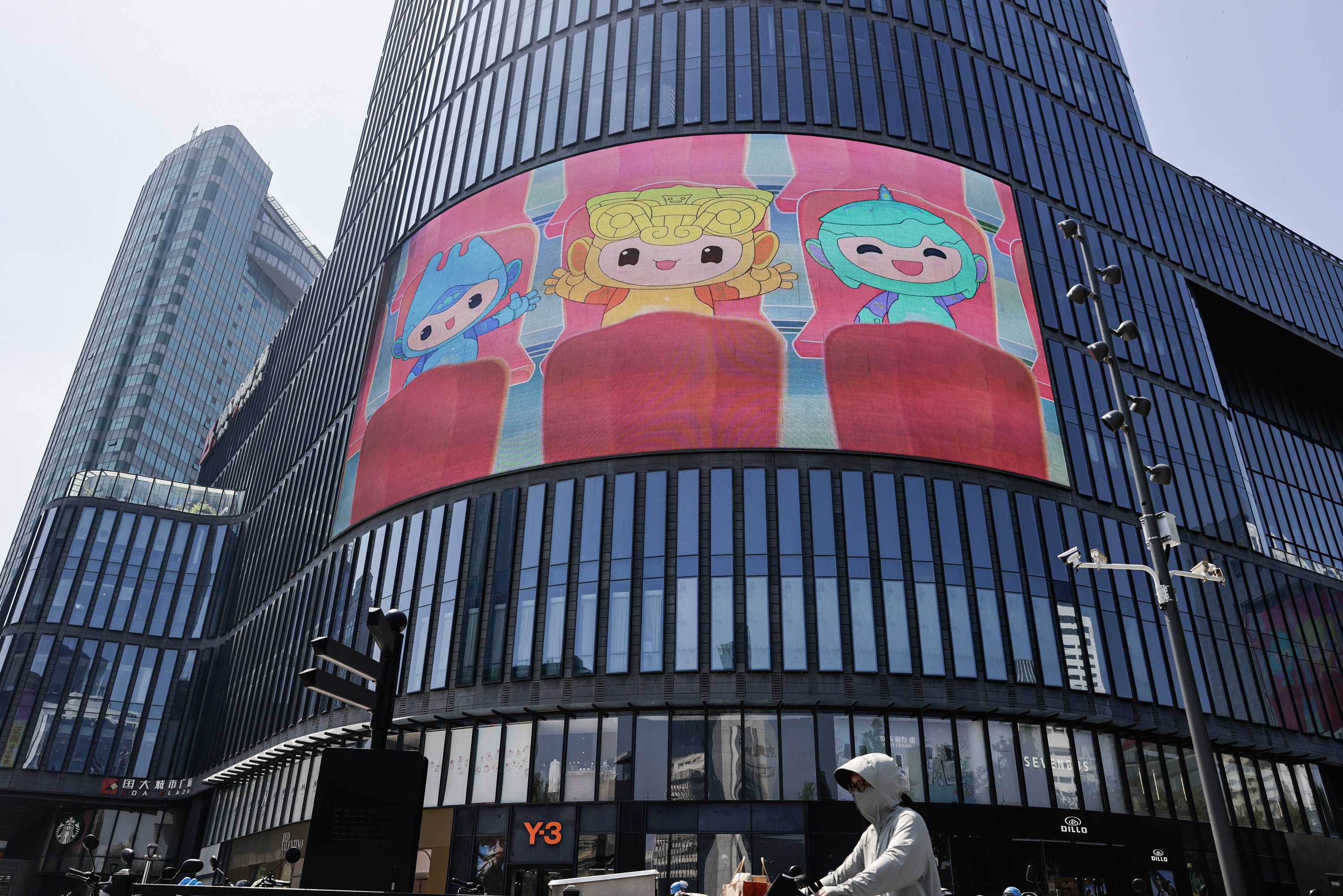 Mascots Chenchen, Congcong and Lianlian are displayed on a large LED screen in downtown Hangzhou, Zhejiang on September 18, 2023. /IC