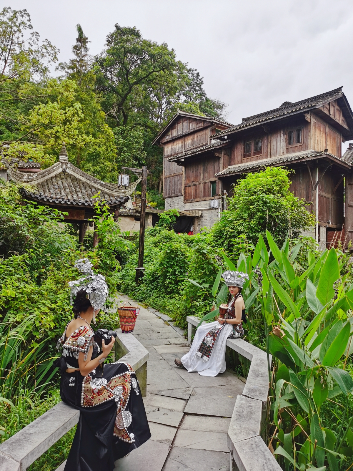 A tourist wearing ethnic dress poses for a photo at Qingyan ancient town in Guiyang, southwest China's Guizhou Province, on August 28, 2023. /CGTN
