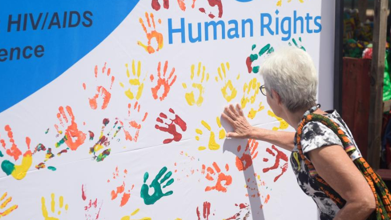 A woman applies paint to a banner during a public event to commemorate the Human Rights Day in Gaborone, Botswana, December 9, 2022. /Xinhua
