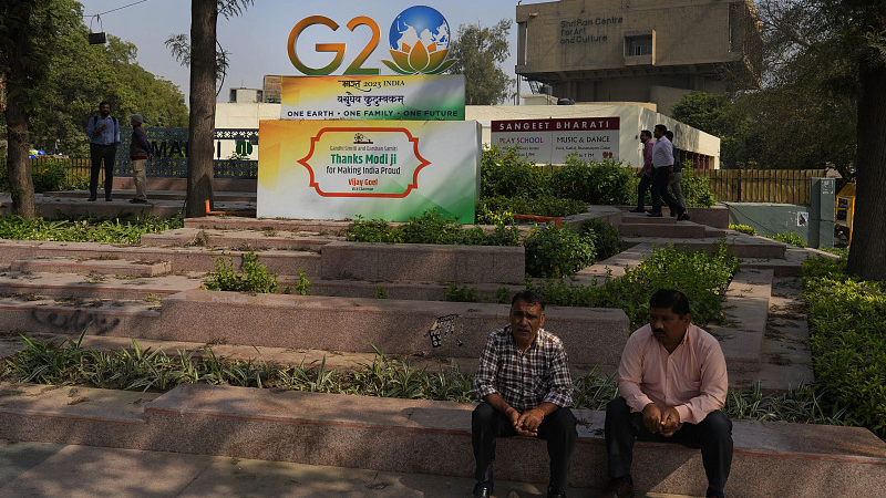 People sit in front of a G20 logo at a crossing in New Delhi, India, February 28, 2023. /CFP