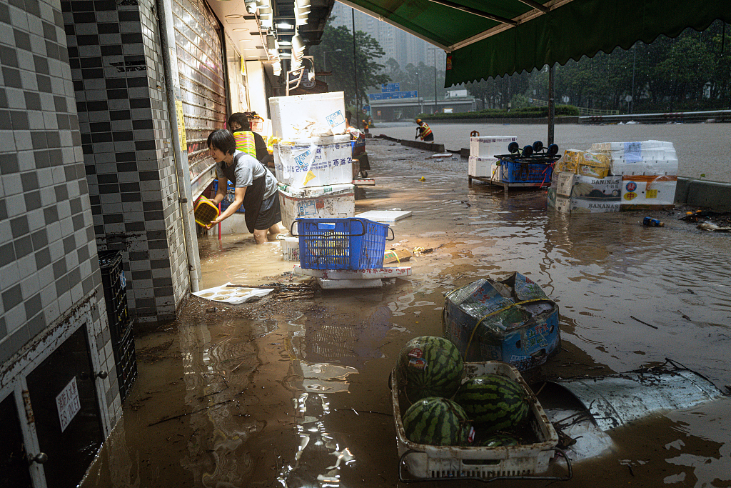 Shopkeepers tend to their flooded stores during heavy rain in Hong Kong, China, September 8, 2023. /CFP 