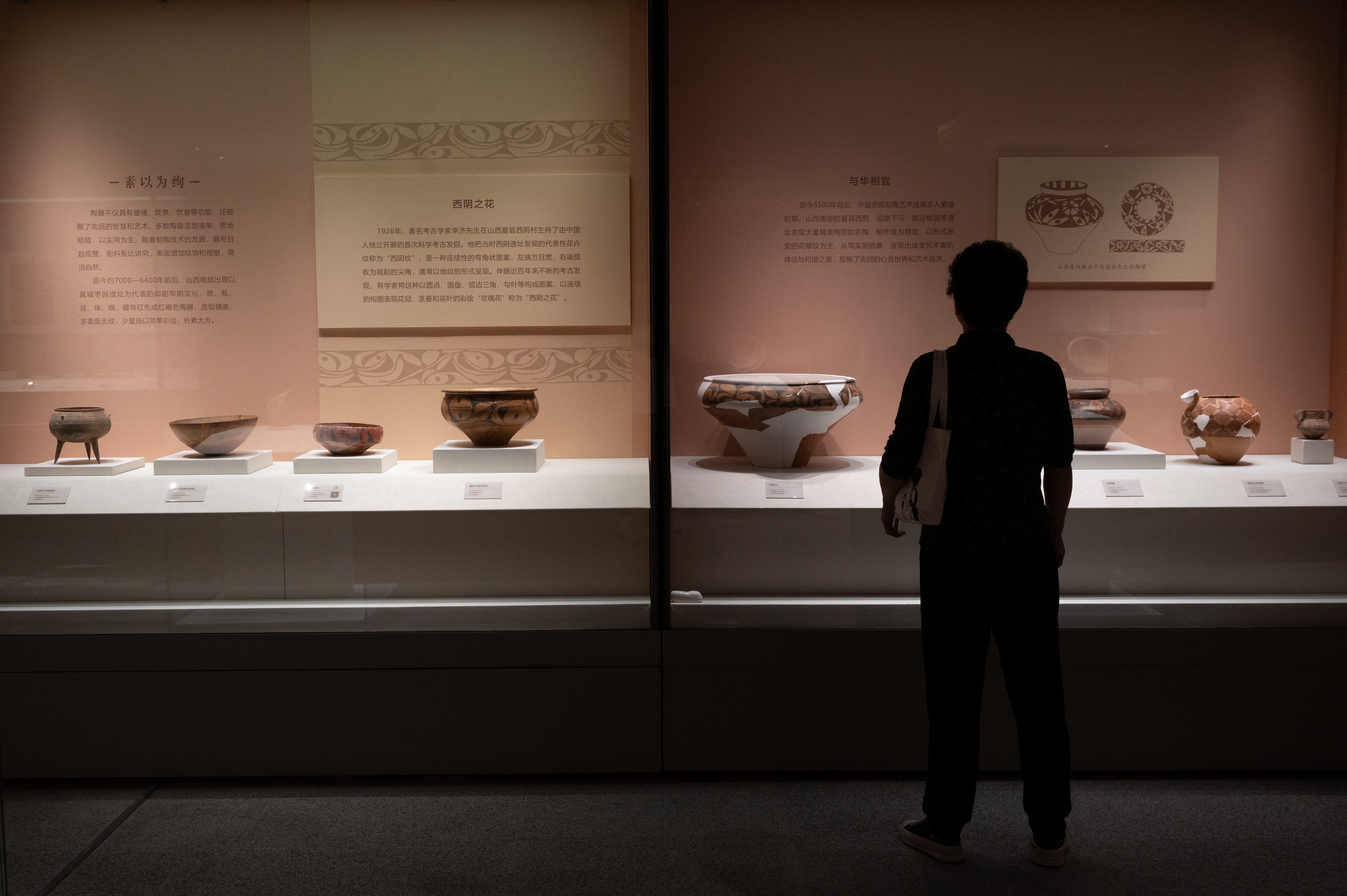 A photo taken on September 22, 2023 shows a visitor viewing cultural relics on display at Shanxi Museum as part of its newly-opened themed exhibition. /IC