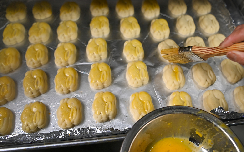 Yang Juxin egg washes the mooncakes to give them a shiny look after baking. /CFP