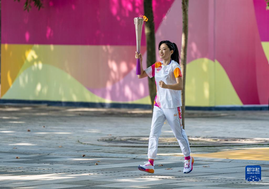 First torch bearer Luo Xuejuan carries the torch in the relay for the 19th Asian Games in Hangzhou, China, September 8, 2023. /Xinhua 