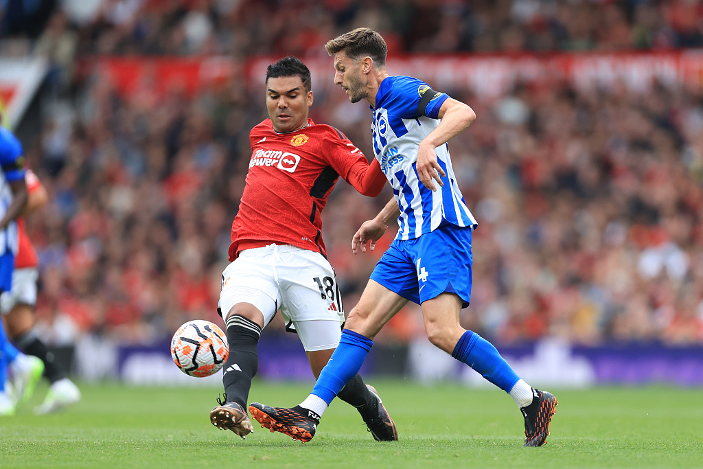 Casemiro (L) of Manchester United competes for the ball with Adam Lallana of Brighton & Hove Albion in a Premier League game at Old Trafford in Manchester, England, September 16, 2023. /CFP 