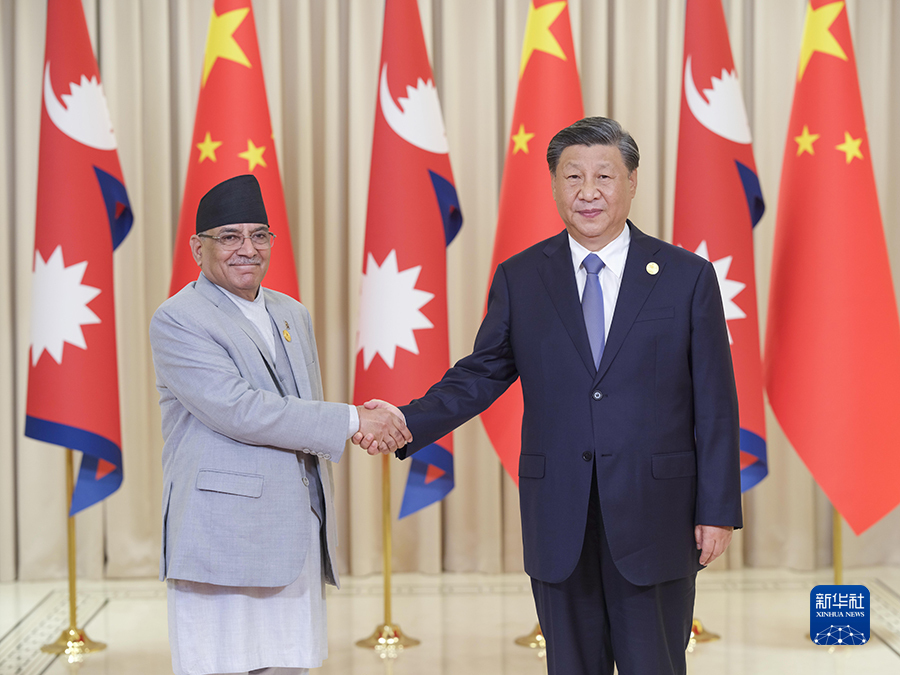 Chinese President Xi Jinping (R) shakes hands with Nepalese Prime Minister Pushpa Kamal Dahal 