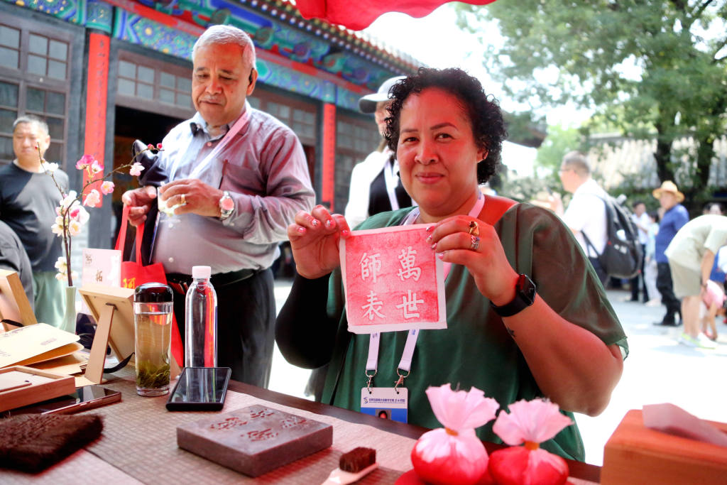 A foreign visitor shows a rubbing made from inscriptions found at the Kong Family Mansion in Qufu, east China's Shandong Province, June 27, 2023. /CFP