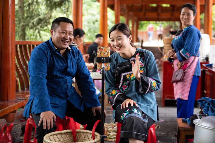 Ma Huihuang (L), then head of the poverty alleviation work team in Shibadong, promotes local products via live-streaming in Shibadong Village of Xiangxi Tujia and Miao Autonomous Prefecture, central China's Hunan Province, May 15, 2020. /Xinhua