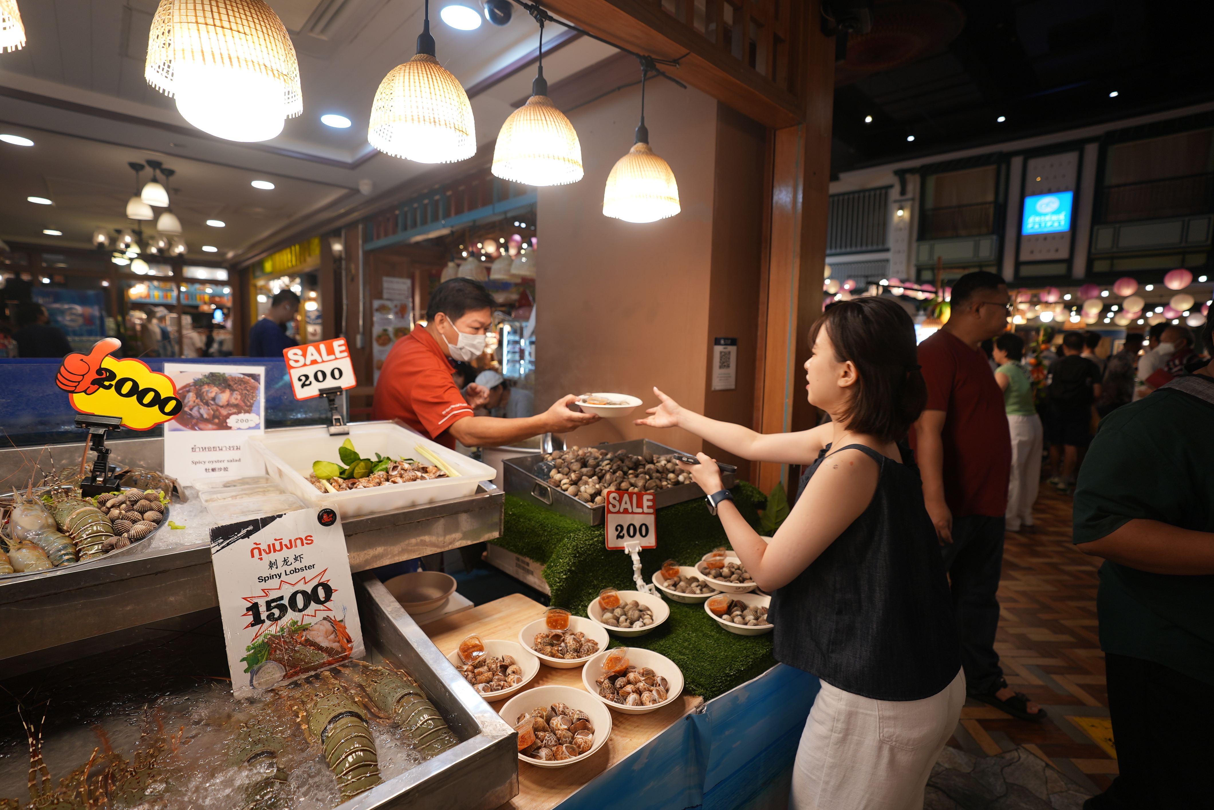 A visitor buys specialty snacks at a local indoor floating market in Bangkok, Thailand on September 18, 2023. /CGTN 