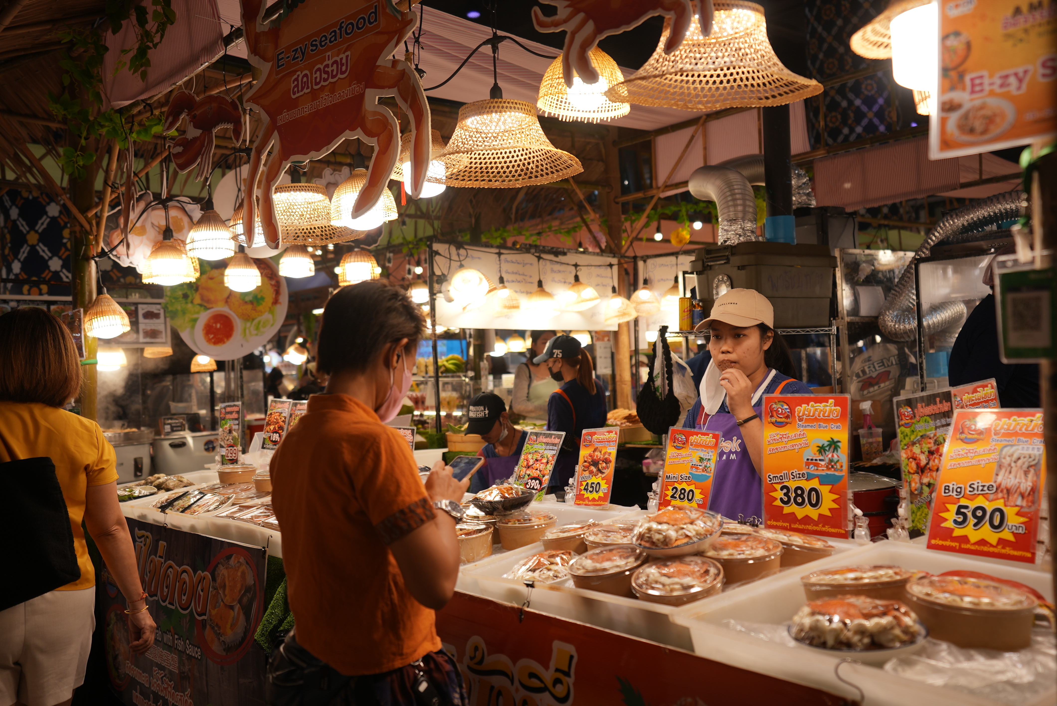A visitor buys specialty snacks at a local indoor floating market in Bangkok, Thailand on September 18, 2023. /CGTN 