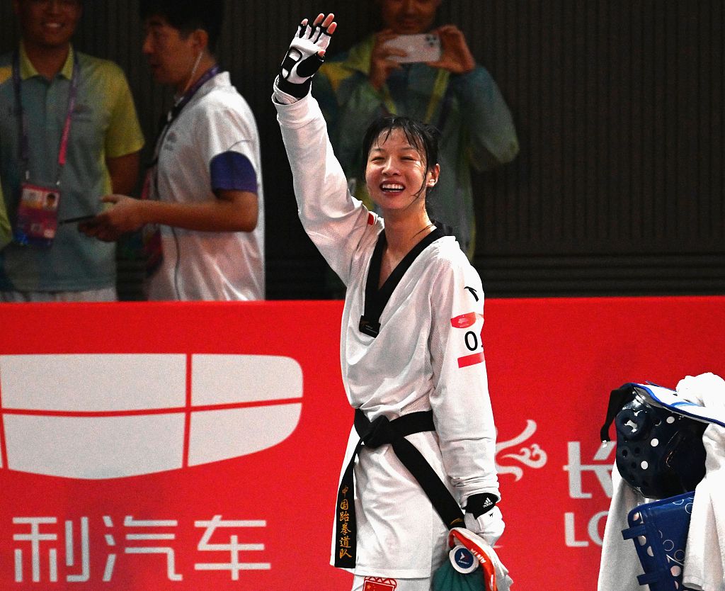 Zhou Zeqi waves to the audience after winning the gold medal in the women's taekwondo +67 kilograms division during the 19th Asian Games in Hangzhou, China, September 28, 2023. /CFP