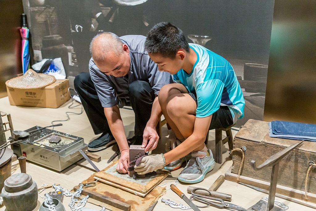 A craftsman shows his handicraft skill at the Zhejiang Intangible Cultural Heritage Museum in Hangzhou, Zhejiang Province. /CFP