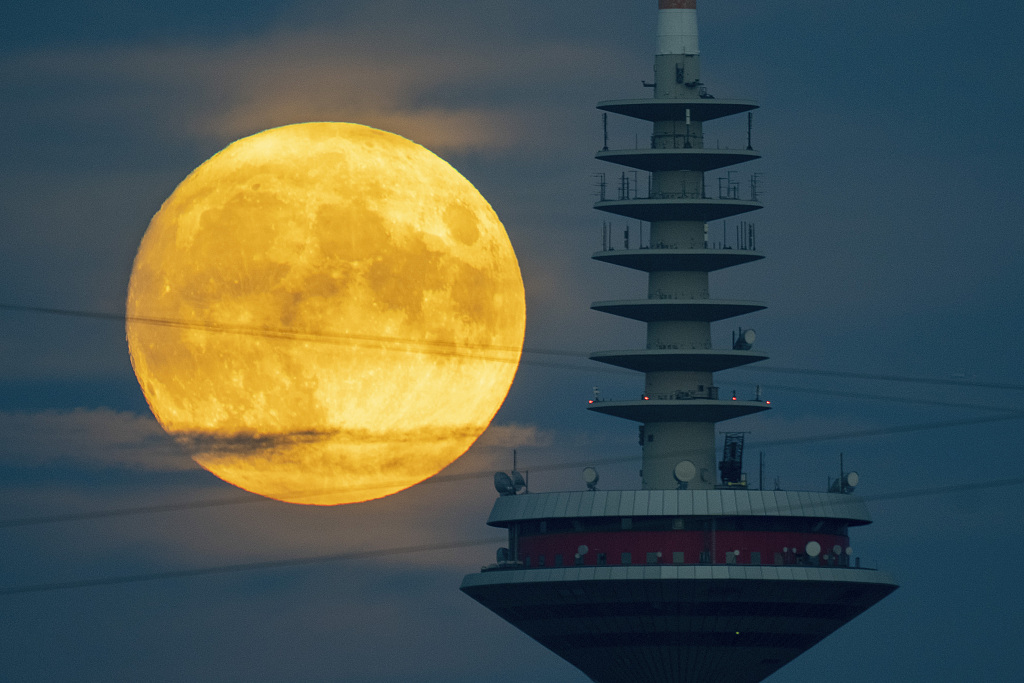 The moon rises next to a television tower in Frankfurt, Germany on September 28, 2023. /CFP