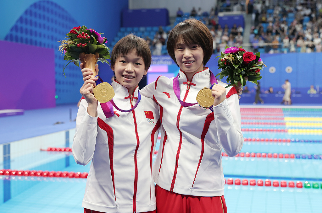Quan Hongchan (L) and Chen Yuxi of China pose with their gold medals after winning the diving women's 10-meter synchronized platform final at the 19th Asian Games in Hangzhou, east China's Zhejiang Province, September 30, 2023. /CFP