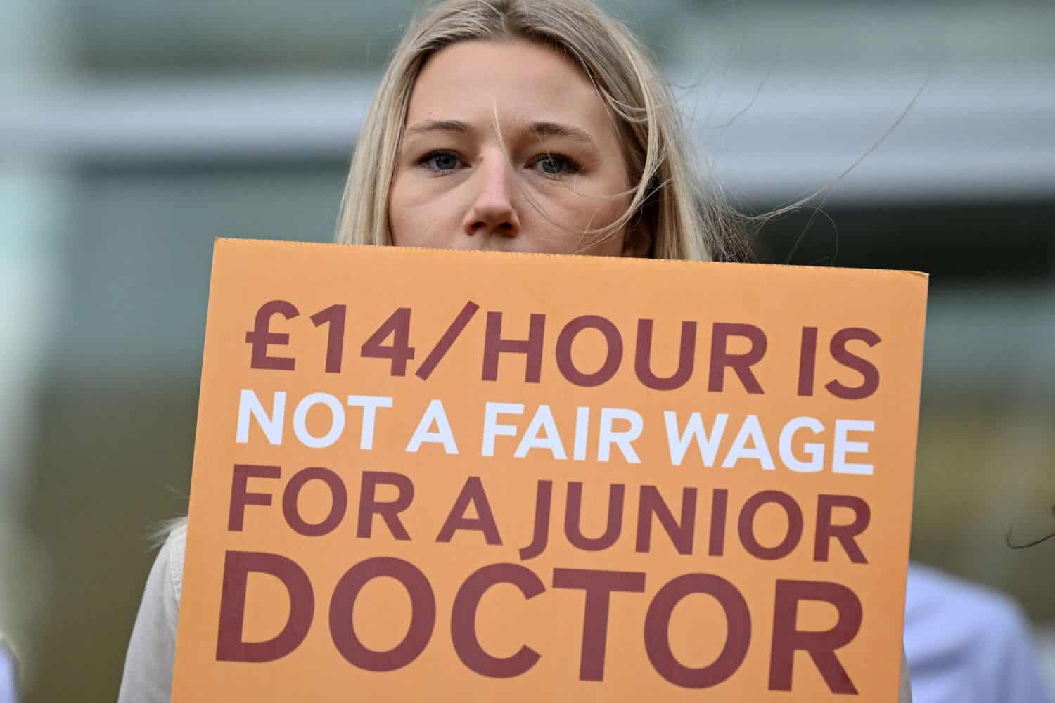 A National Health Service worker holds a placard at a picket line outside University College Hospital in central London, September 20, 2023. /AFP