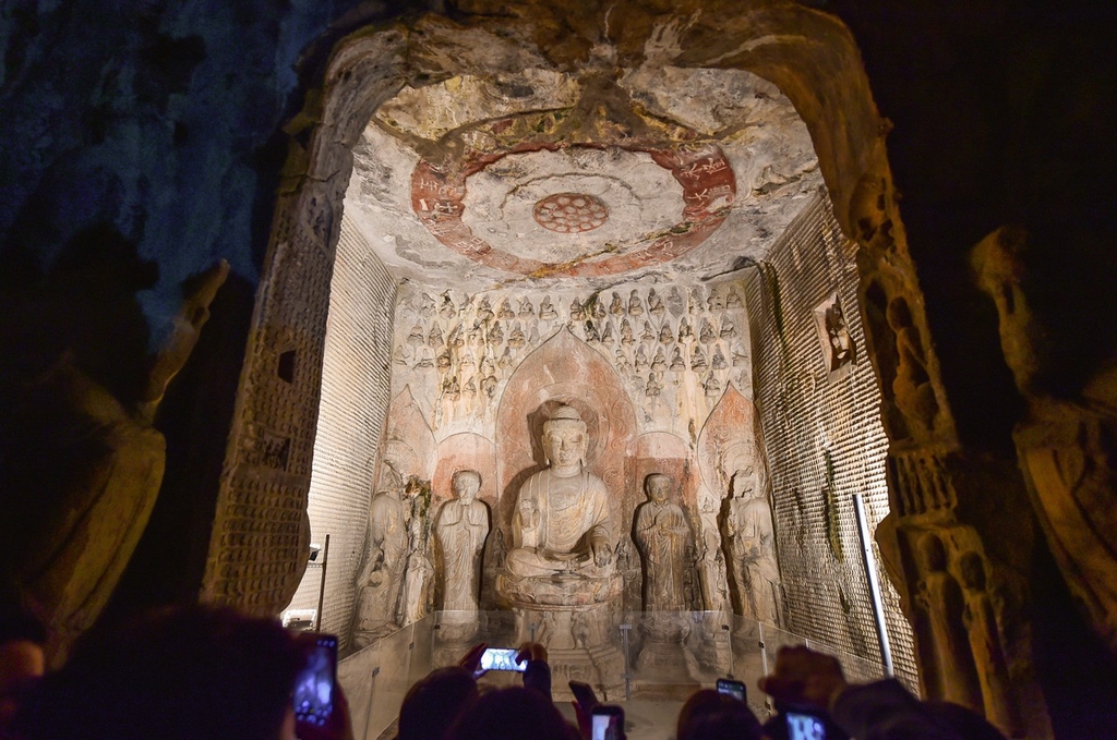 Tourists take pictures at the Longmen Grottoes on October 2, 2023 in Luoyang, Henan. /IC