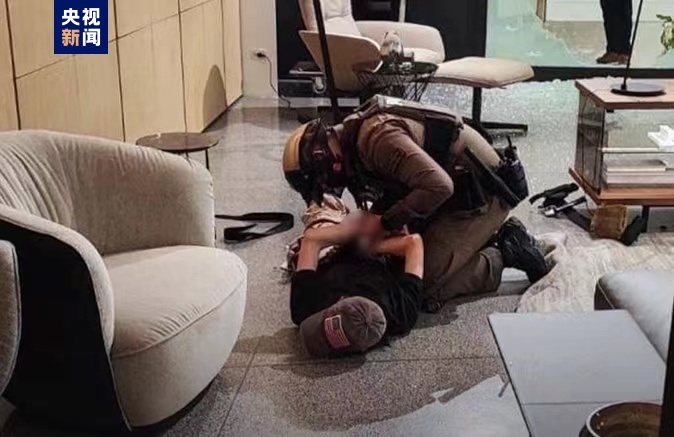 A police officer apprehends and handcuffs an individual lying face down on the floor in the Siam Paragon mall, Bangkok, Thailand, October 3, 2023. /CMG