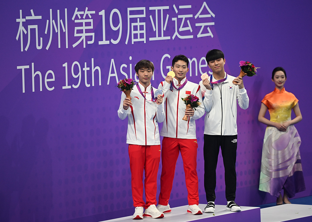 L-R: Zheng Jiuyuan and Wang Zongyuan of China and Yi Jaegyeong of ROK celebrate on the podium after their men's 3m springboard diving final during the 19th Asian Games in Hangzhou, China, October 3, 2023. /CFP