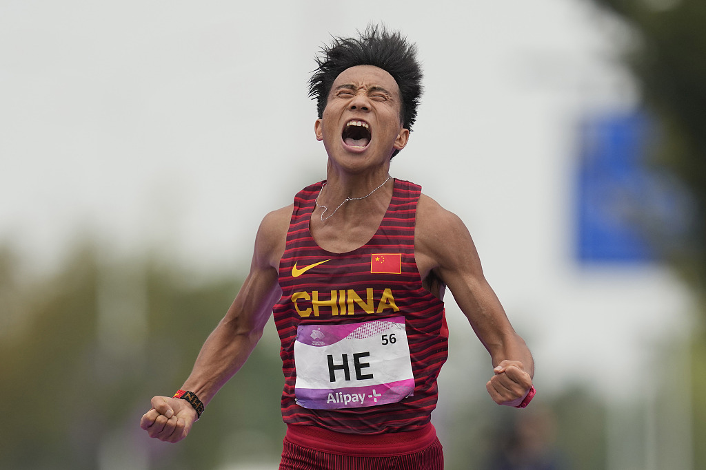 China's He Jie reacts as he crosses the finish line to win the men's marathon event at the 19th Asian Games in Hangzhou, Zhejiang Province, October 5, 2023. /CFP