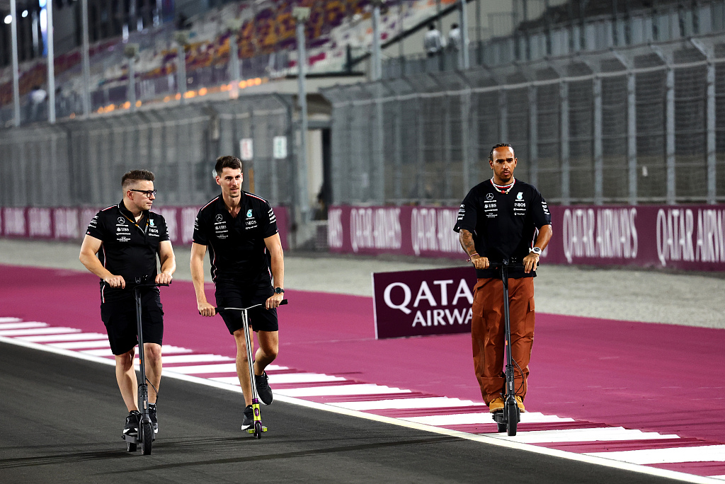 Lewis Hamilton (R) of Mercedes rides a scooter on track during previews ahead of the F1 Grand Prix of Qatar at Lusail International Circuit in Lusail, Qatar, October 5, 2023. /CFP