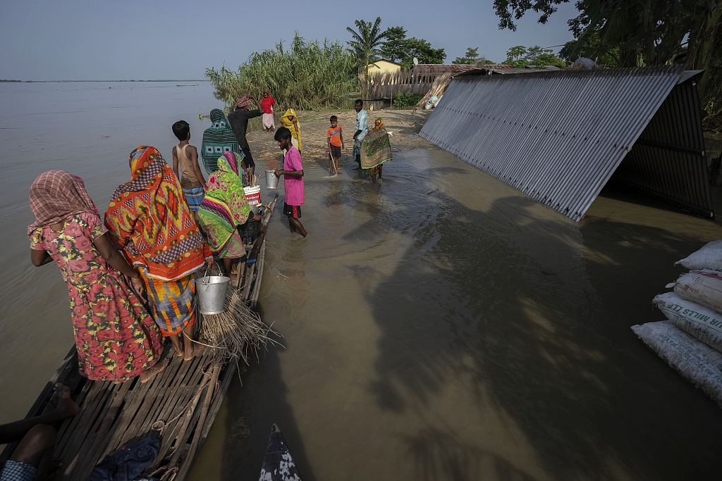 Villagers reach higher ground after they left their submerged house in Sandahkhaiti, a floating island village in the Brahmaputra River in Morigaon district, Assam, India, August 29, 2023. /CFP