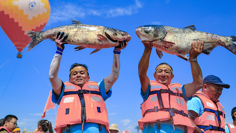 The fishermen display the freshly-caught fish at Bosten Lake in the Bayingolin Mongolian Autonomous Prefecture of northwest China's Xinjiang Uygur Autonomous Region, June 23, 2023. /CFP