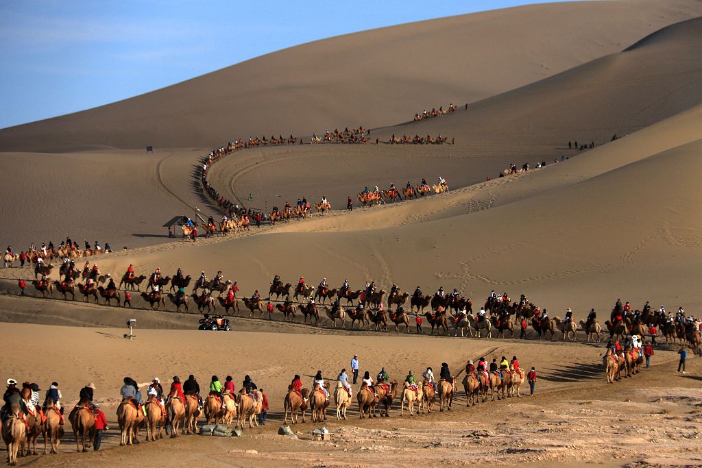 A photo taken on September 29, 2023 shows tourists riding camels in Jiuquan, Gansu. /CFP