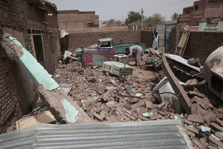 A man cleans debris of a house hit in recent fighting in Khartoum, Sudan, April 25, 2023. /CFP