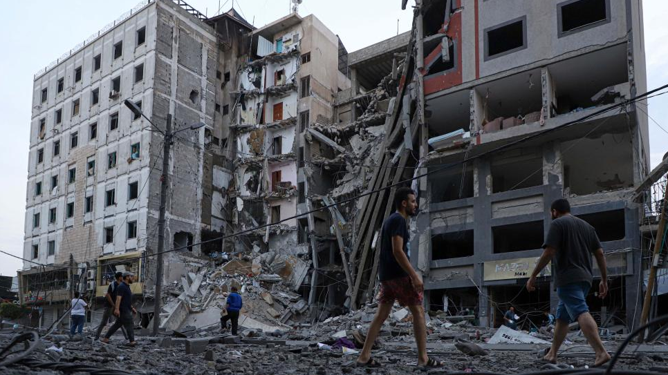 Palestinians check destroyed buildings following an Israeli airstrike in Gaza City, October 8, 2023. /Xinhua