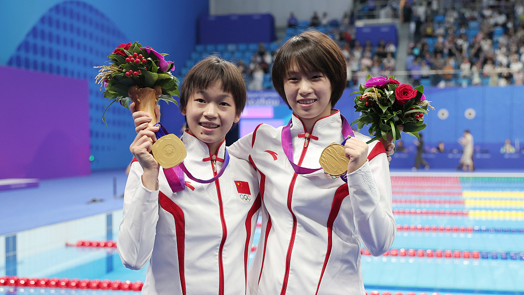 Quan Hongchan (L) and Chen Yuxi of China pose with their gold medals after winning the diving women's 10-meter synchronized platform final at the 19th Asian Games in Hangzhou, China's Zhejiang Province, September 30, 2023. /CFP