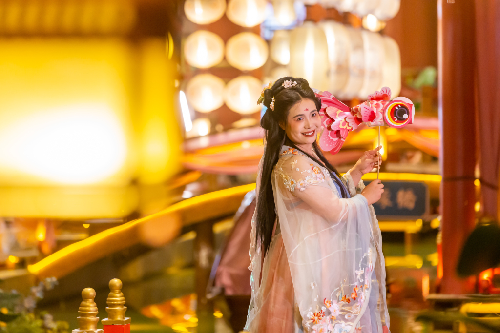 A tourist dressed in hanfu costume poses for a photo in Zhengzhou, central China's Henan Province, June 14, 2023. /CFP