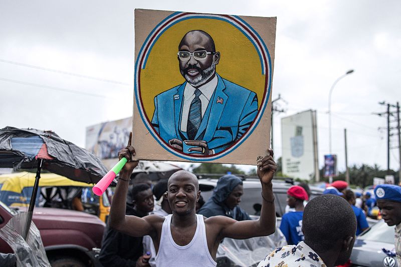 A supporter holds up a painting of the incumbent Liberian President George Weah ahead of a final campaign rally in Monrovia, October 8, 2023. /CFP